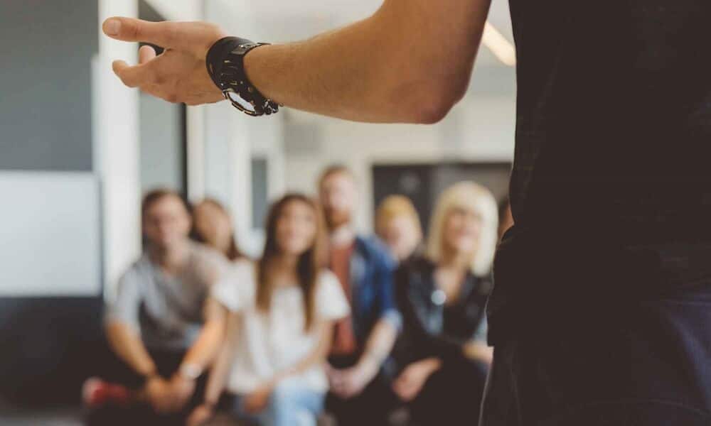 Closeup of arm with watch talking with audience of peers at Mountainside Treatment Center