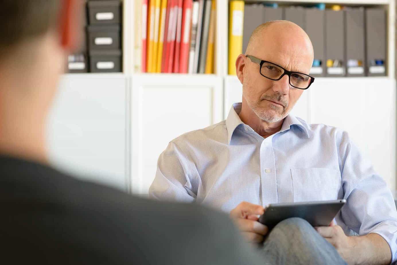 Male drug and alcohol clinician in an individual counseling session with a client