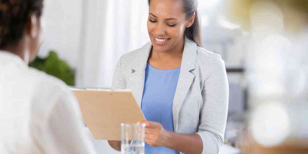 Addiction treatment professional wearing a blazer and holding a clipboard.
