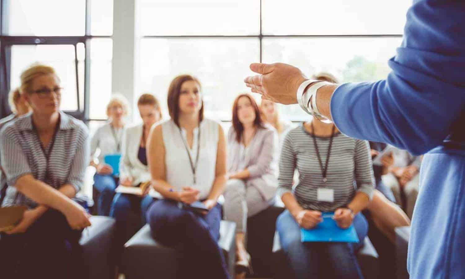 A group of professionals in a conference or meeting, listening to a speaker.