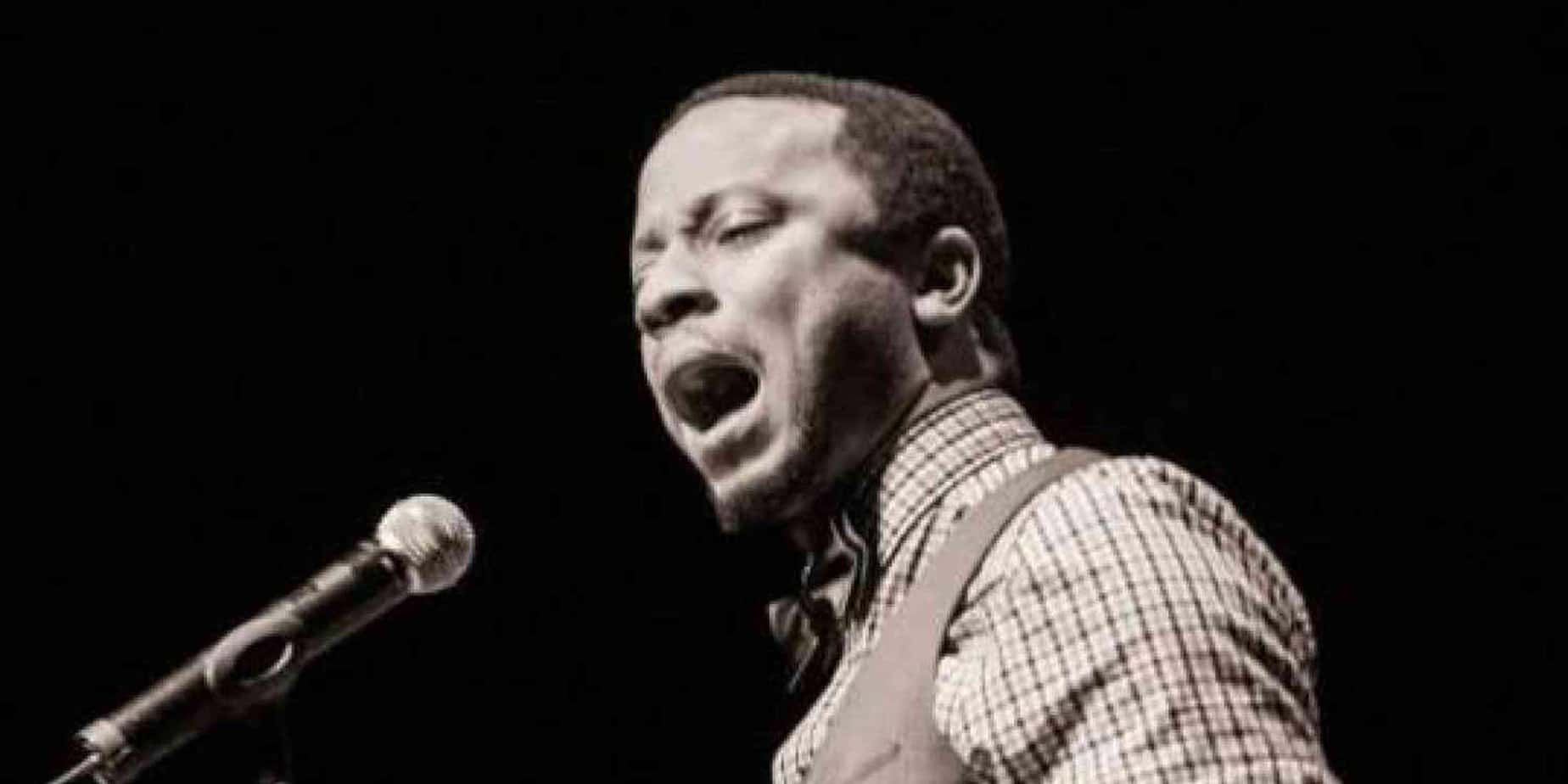black and white photo of man singing into microphone