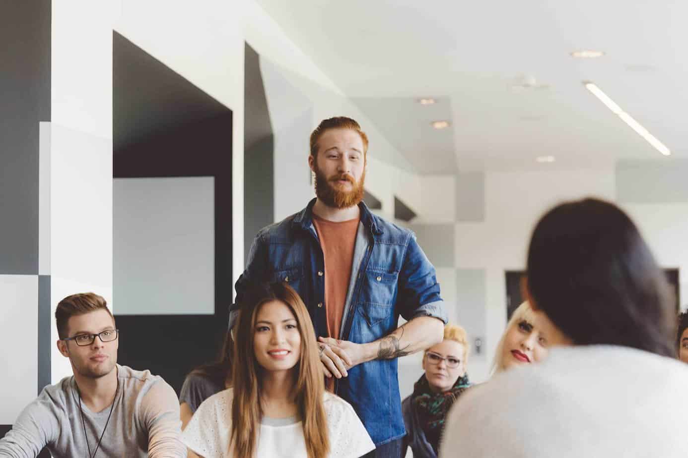 man standing up in recovery meeting in white room