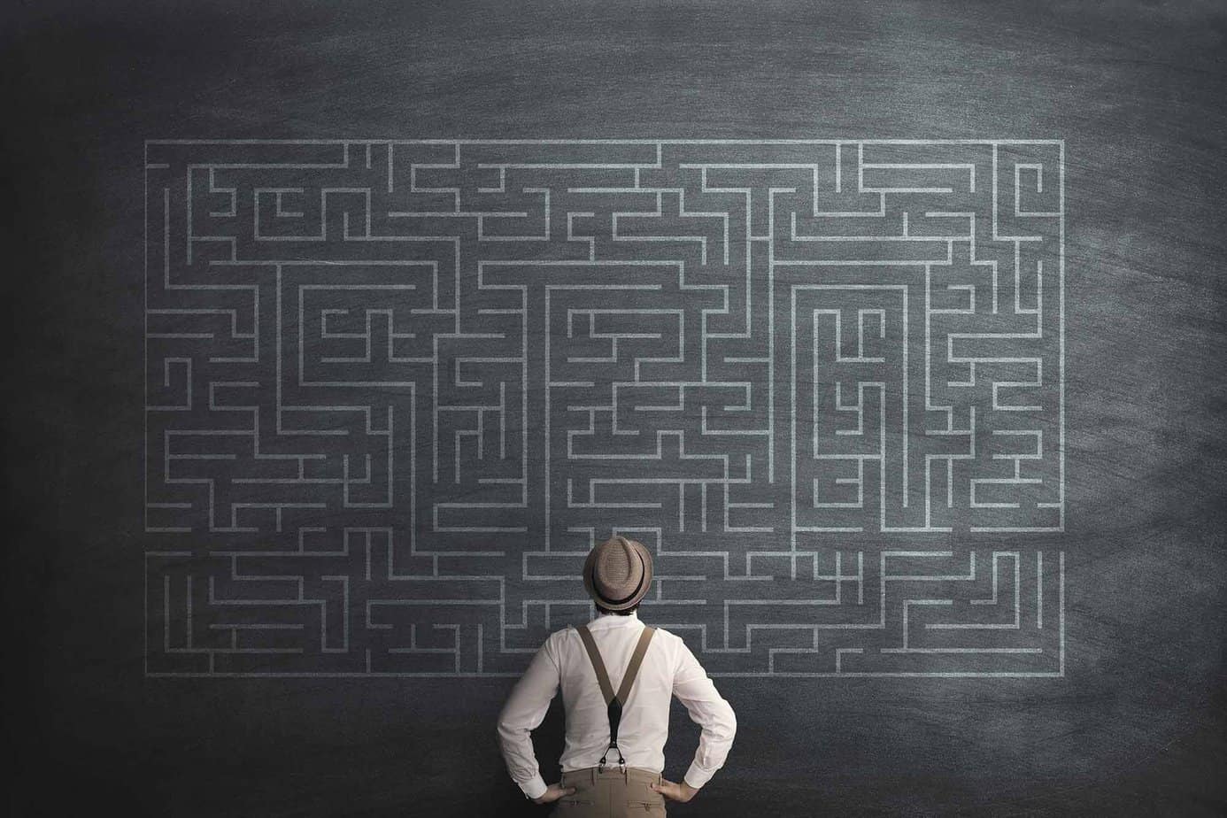man in hat and suspenders looking at possible mistakes in recovery on a chalkboard with maze drawn