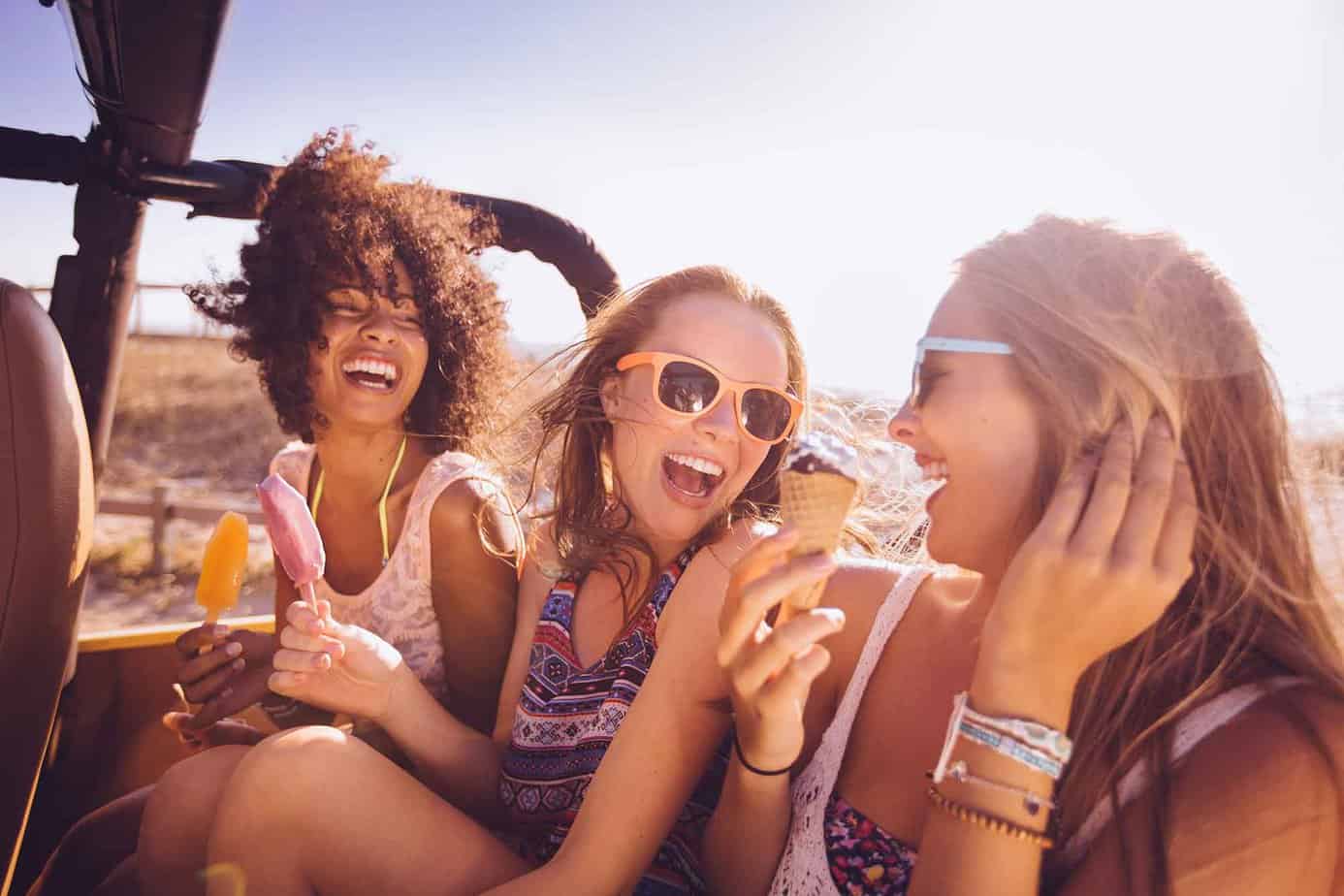 group of three teen girls laughing in the car