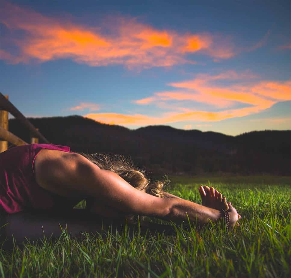 woman lying in empty field as the sun sets practicing holistic drug withdrawal
