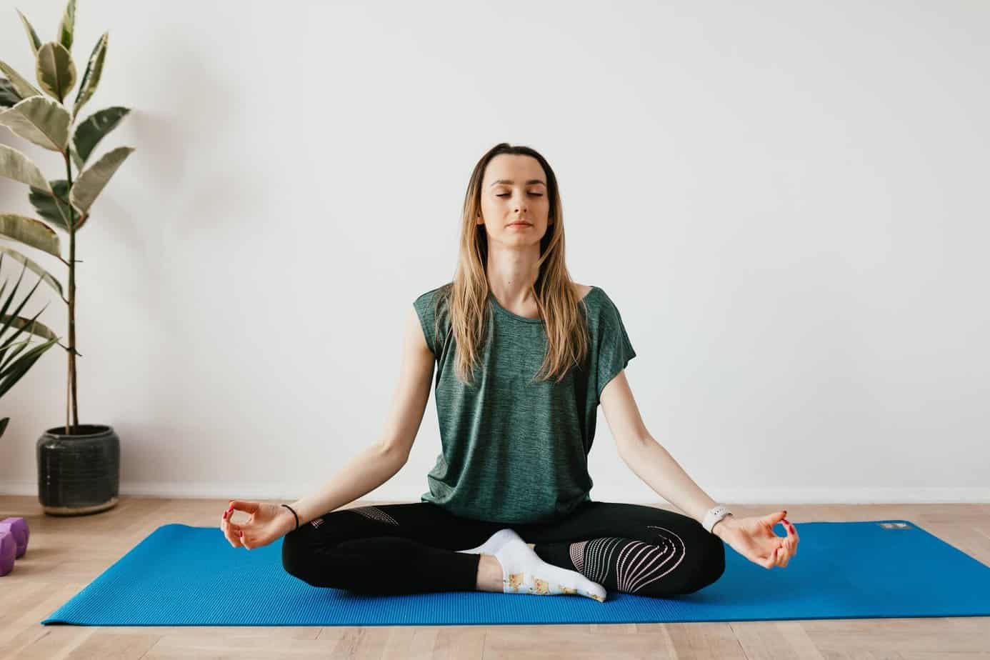 woman seated on yoga mat meditating