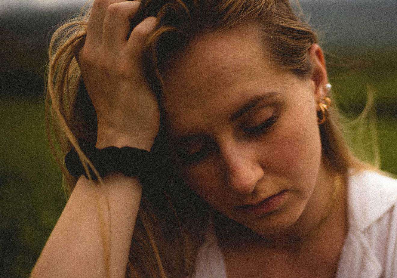 woman looking sad with hand in hair