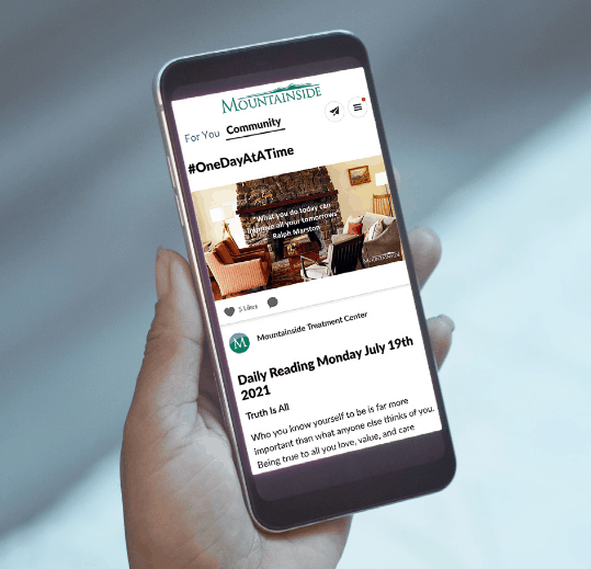 Hand holding Iphone cellphone with Mountainside Treatment Center App loaded