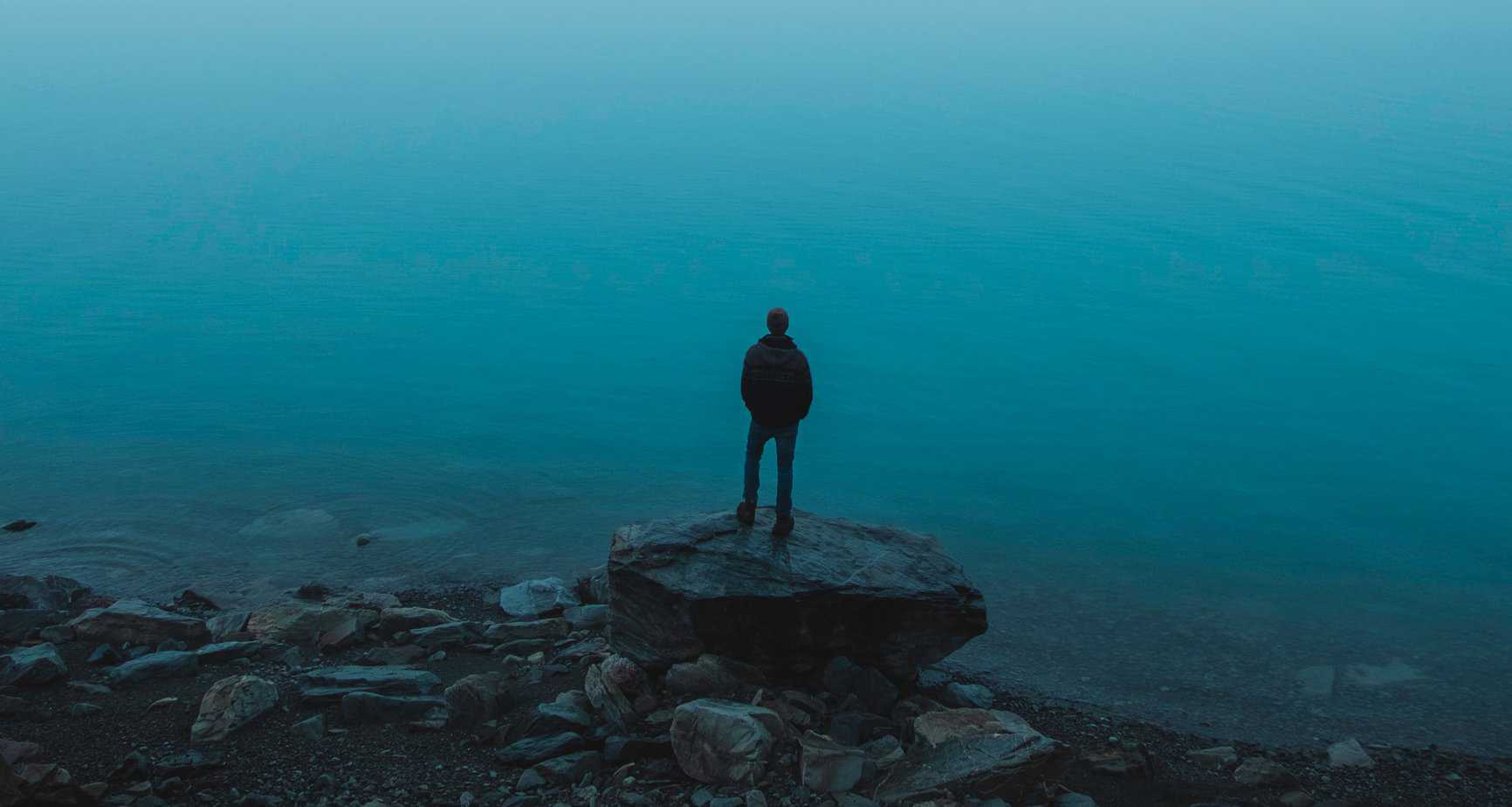 person staring out into the distance thinking about trauma and addiction