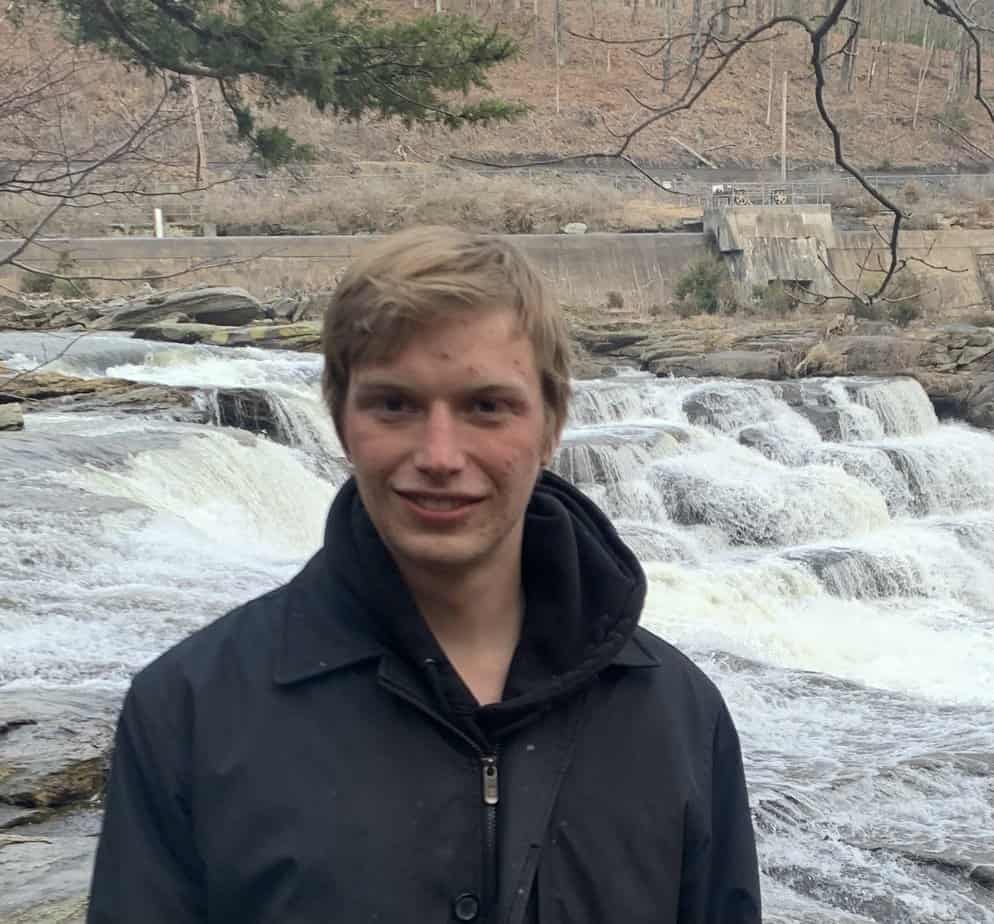 man standing by rushing river in nature