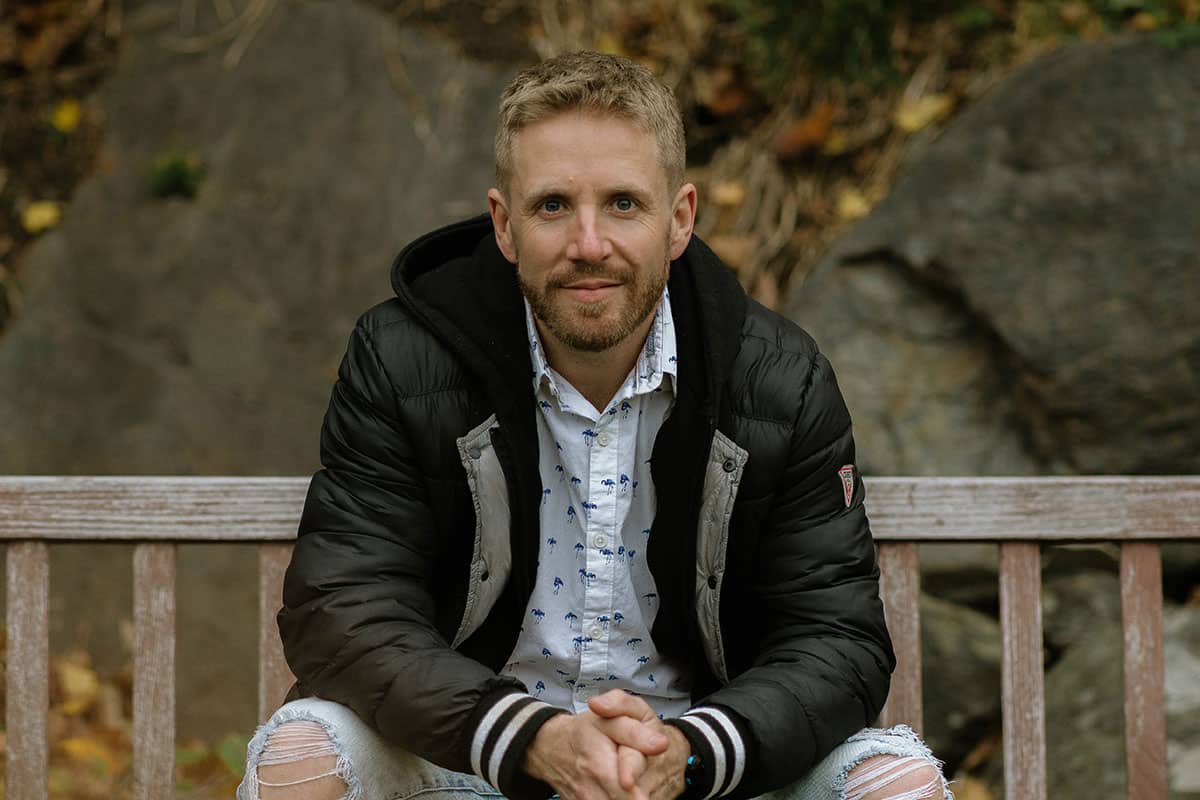 man sitting on bench in park in autumn