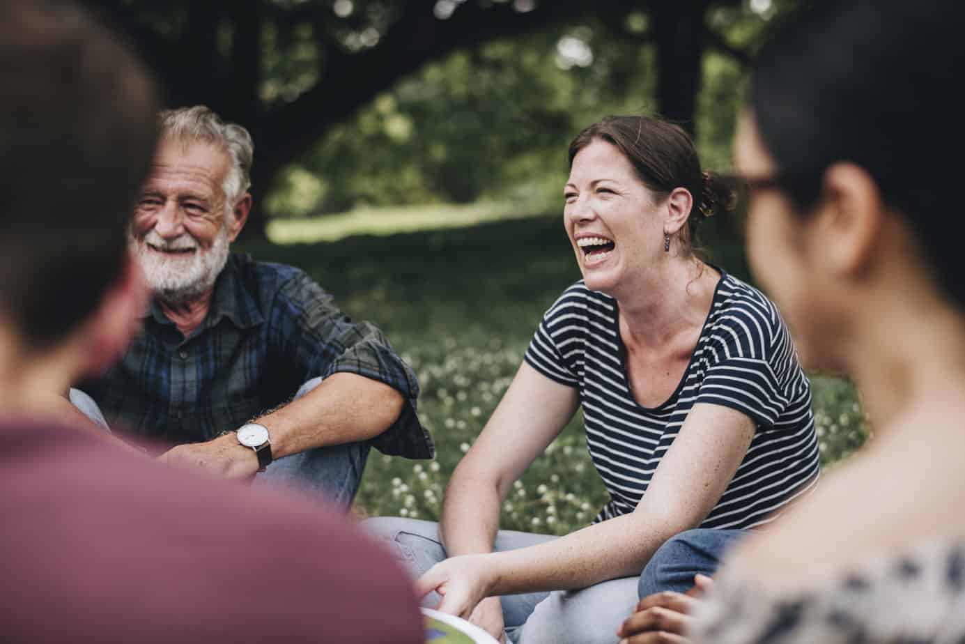 happy woman in recovery smiling with friends in park