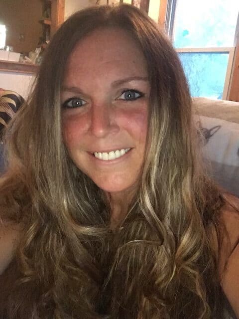 selfie of smiling blonde woman seated on couch