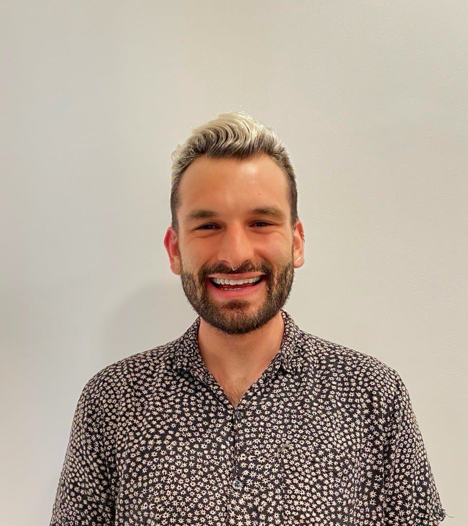 smiling man with bleached hair poses for portrait