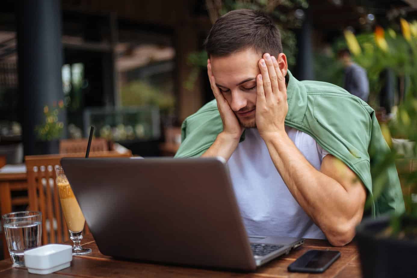Frustrated man looks at laptop to learn about addiction