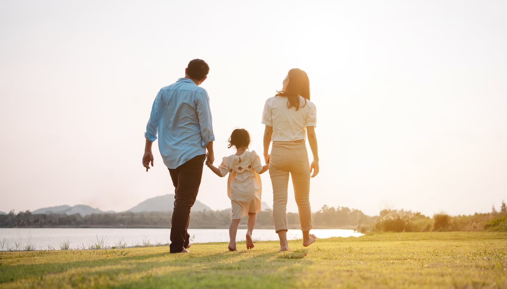 Family walking in the park at sunset