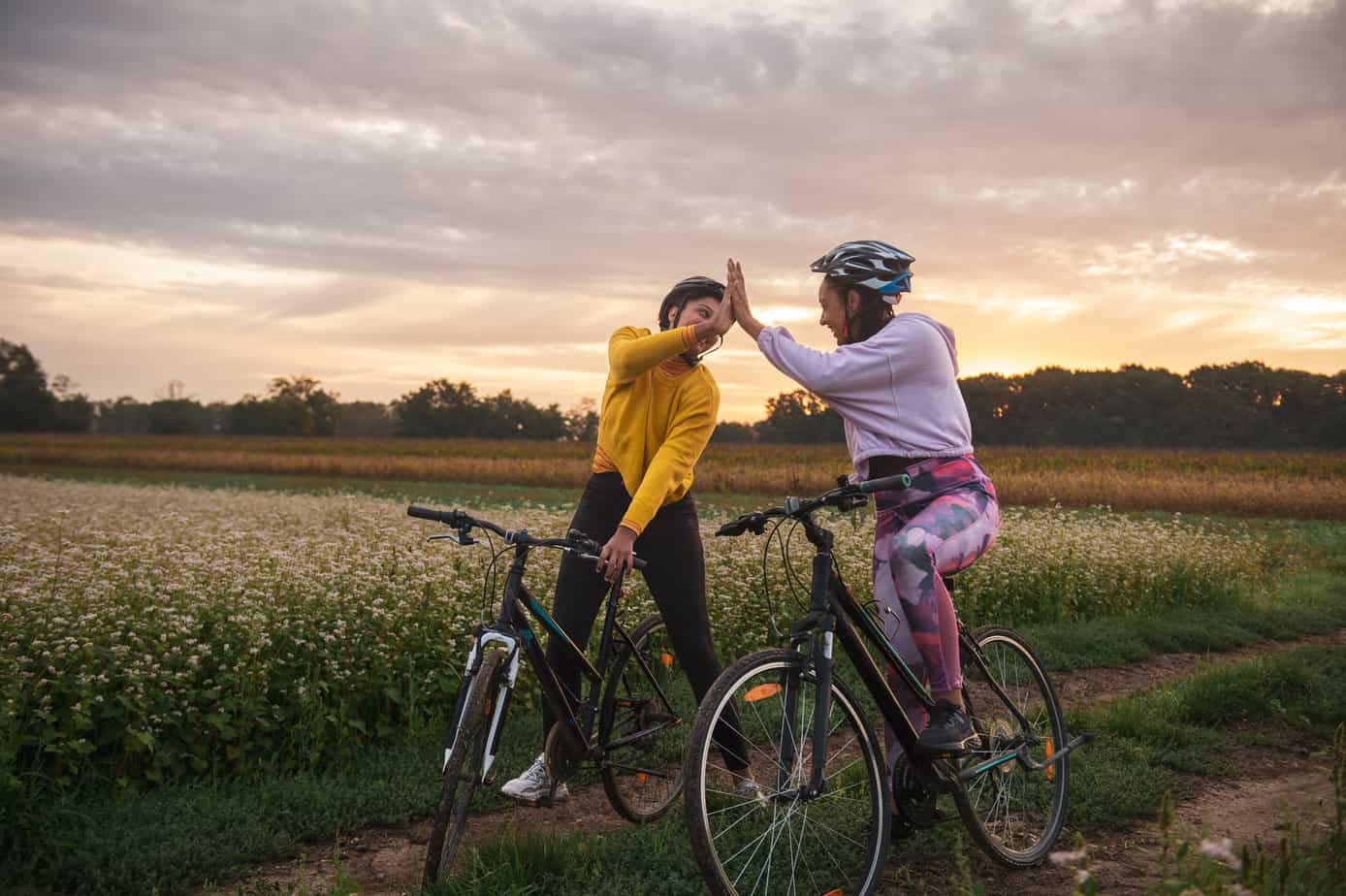 two bikers give high five near a field deal with loneliness and form friendship