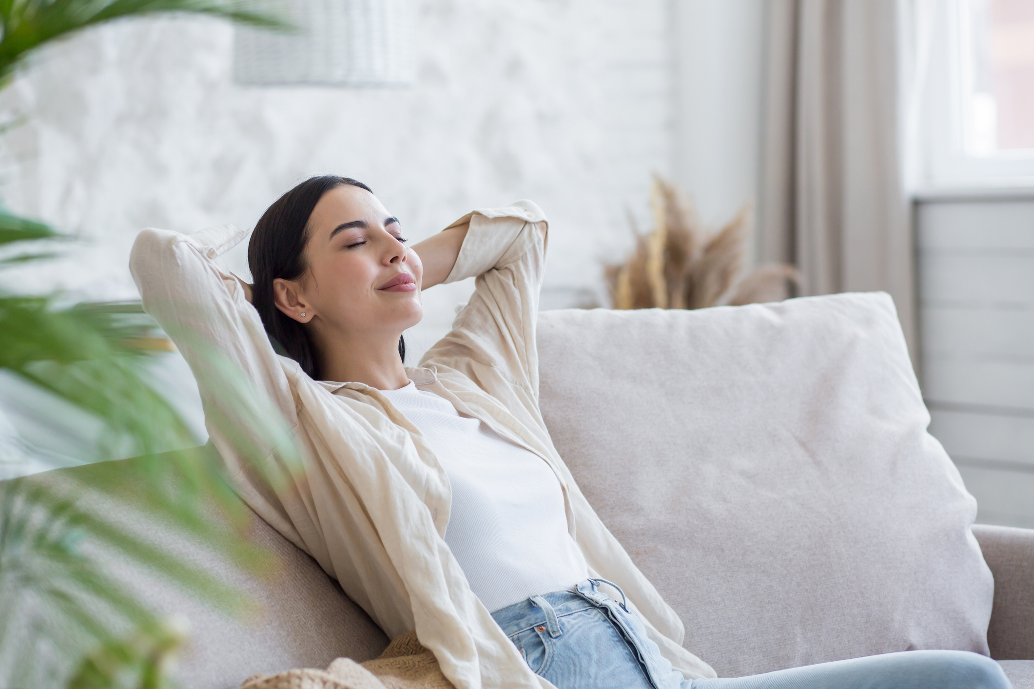 brunette woman resting on couch in bespoke treatment room