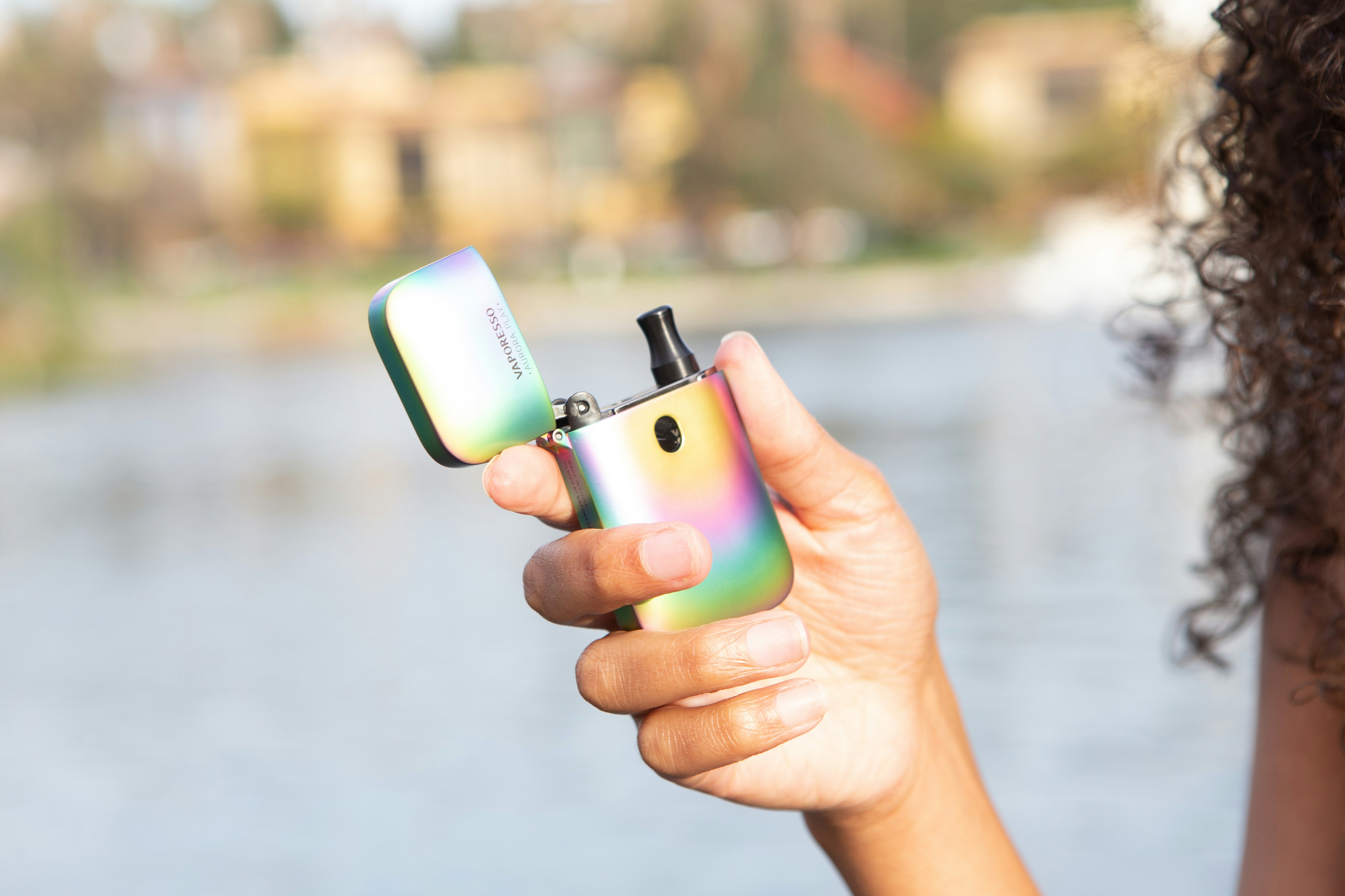 A colorful nicotine vape is being held in a person's hand