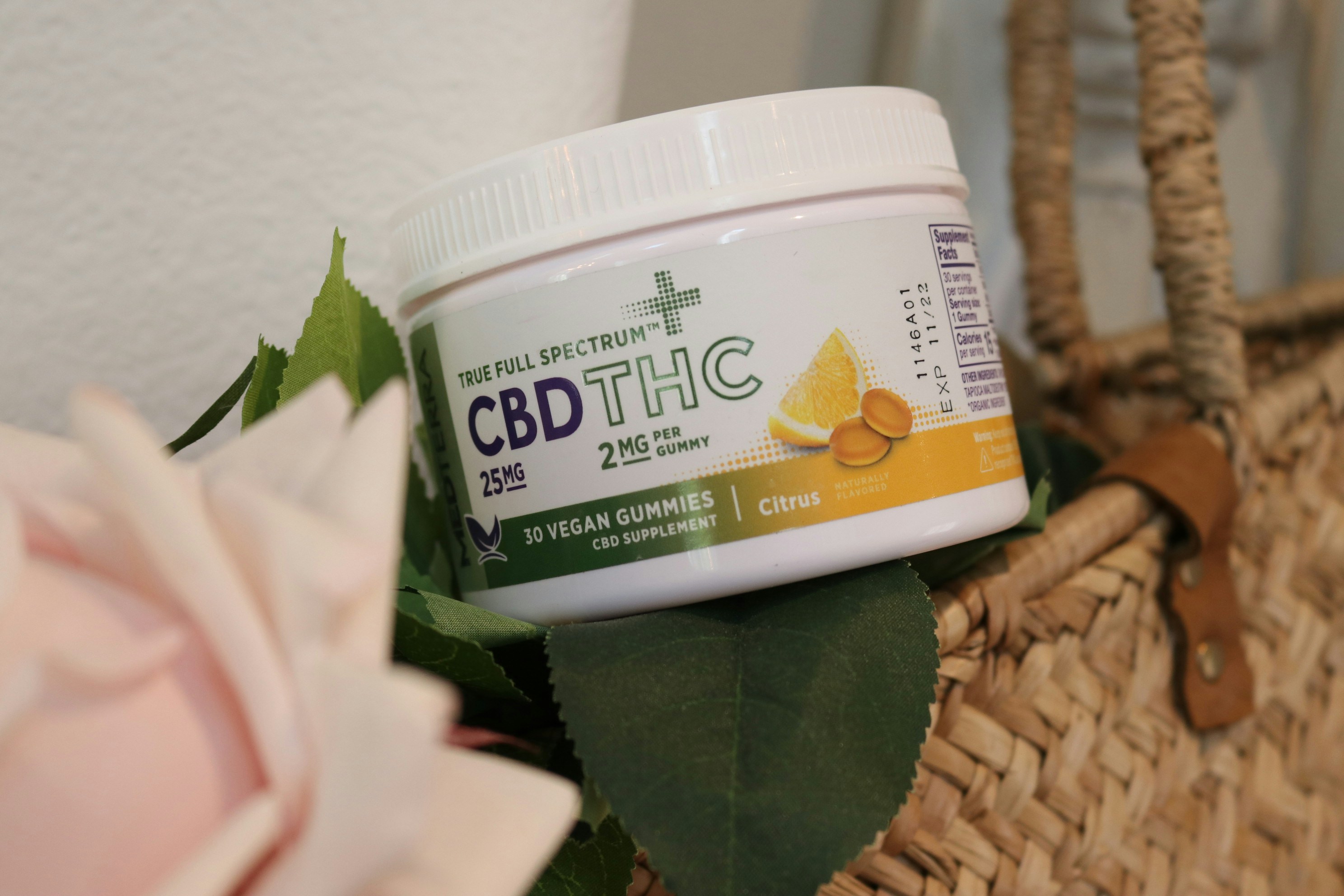 A container with THC and CBD product sits atop a basket