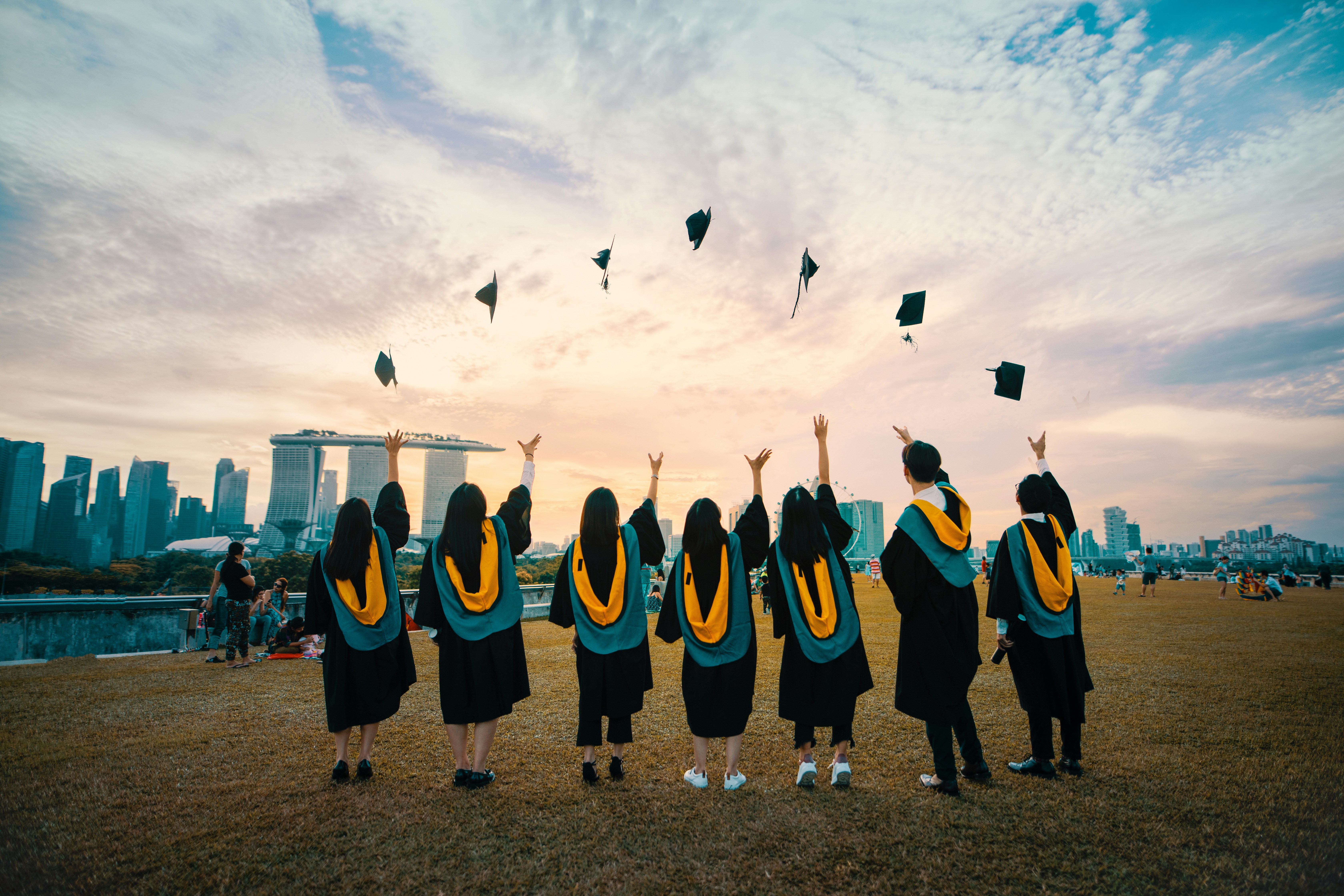 students in a collegiate recovery program throw their caps in the air